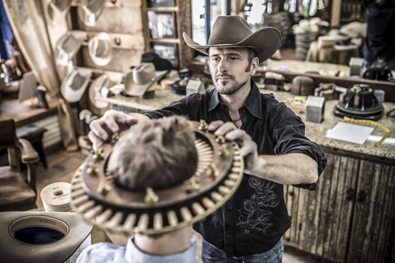 Jeff Biggar measuring the head of a gentleman for a custom hat